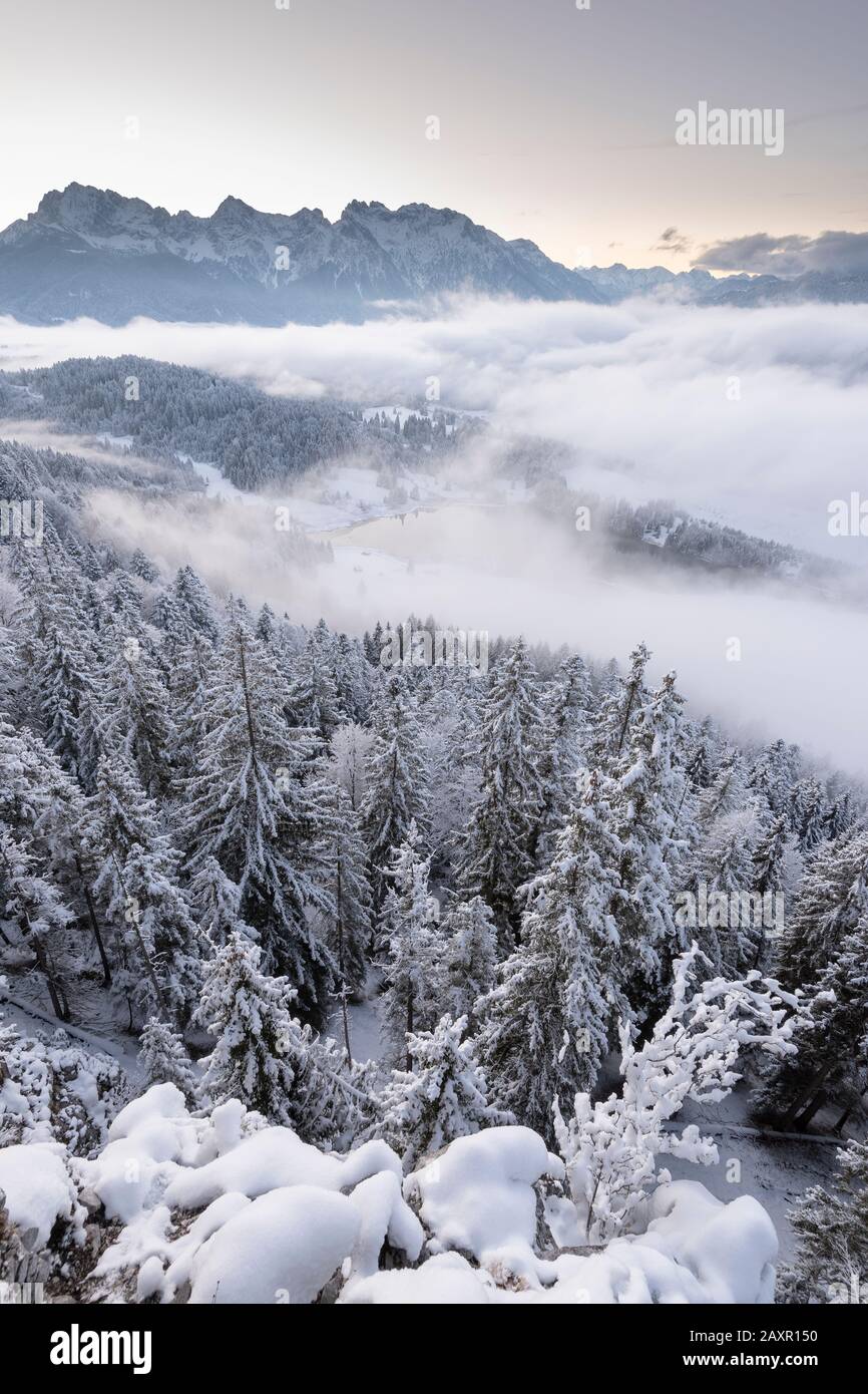 Misty mood and dawn above the Geroldsee with a view to the Karwendel mountains in winter Stock Photo