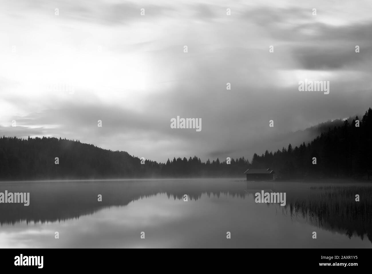 Boathouse on the shore of Lake Fechensee in the fog after sunset Stock Photo