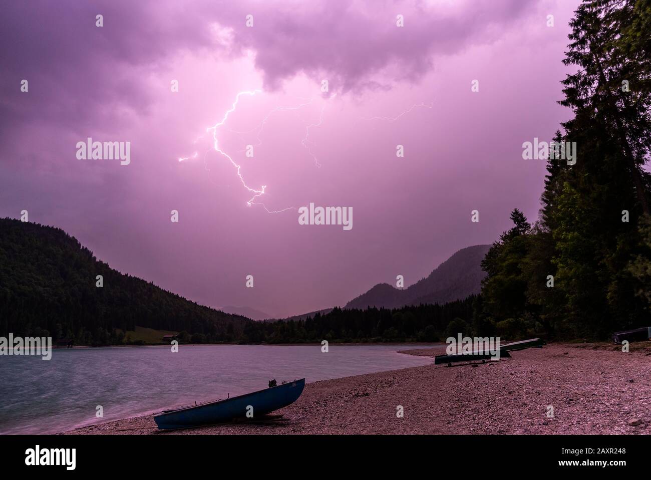 A lightning storm over the boat mooring at lake Walchensee in the bavarian alps. Stock Photo