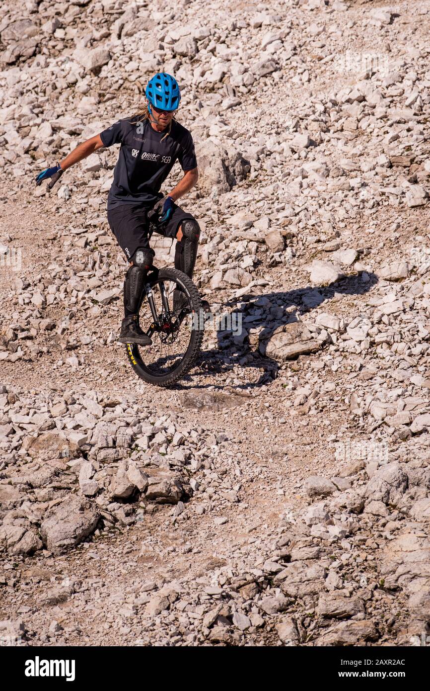 The well-known alpine unicyclist Michael Rung in the Karwendel mountains at over 2300 m height with his unicycle. Stock Photo