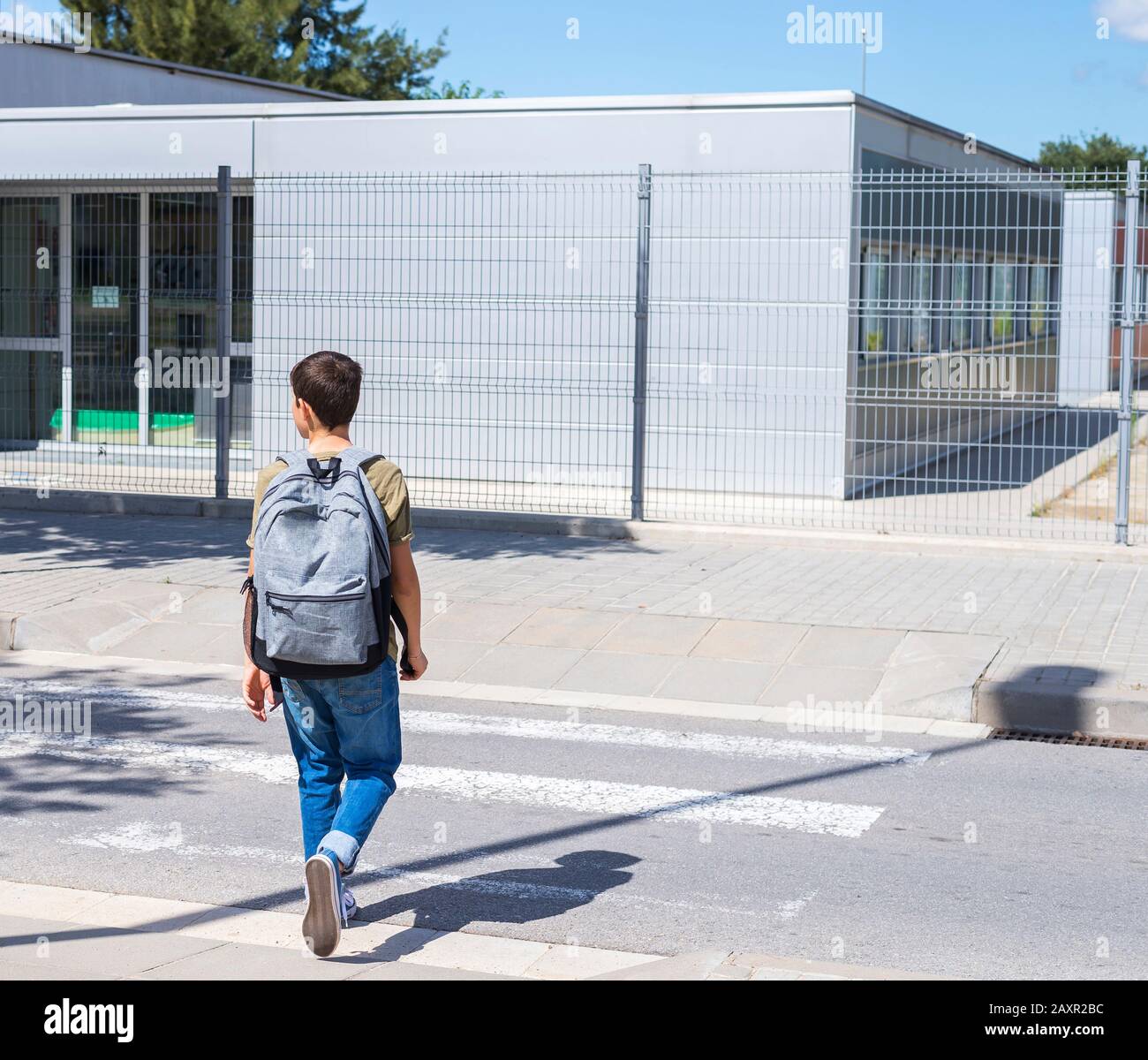 Teenage school boy with a backpack on his back walking to school ( back ...