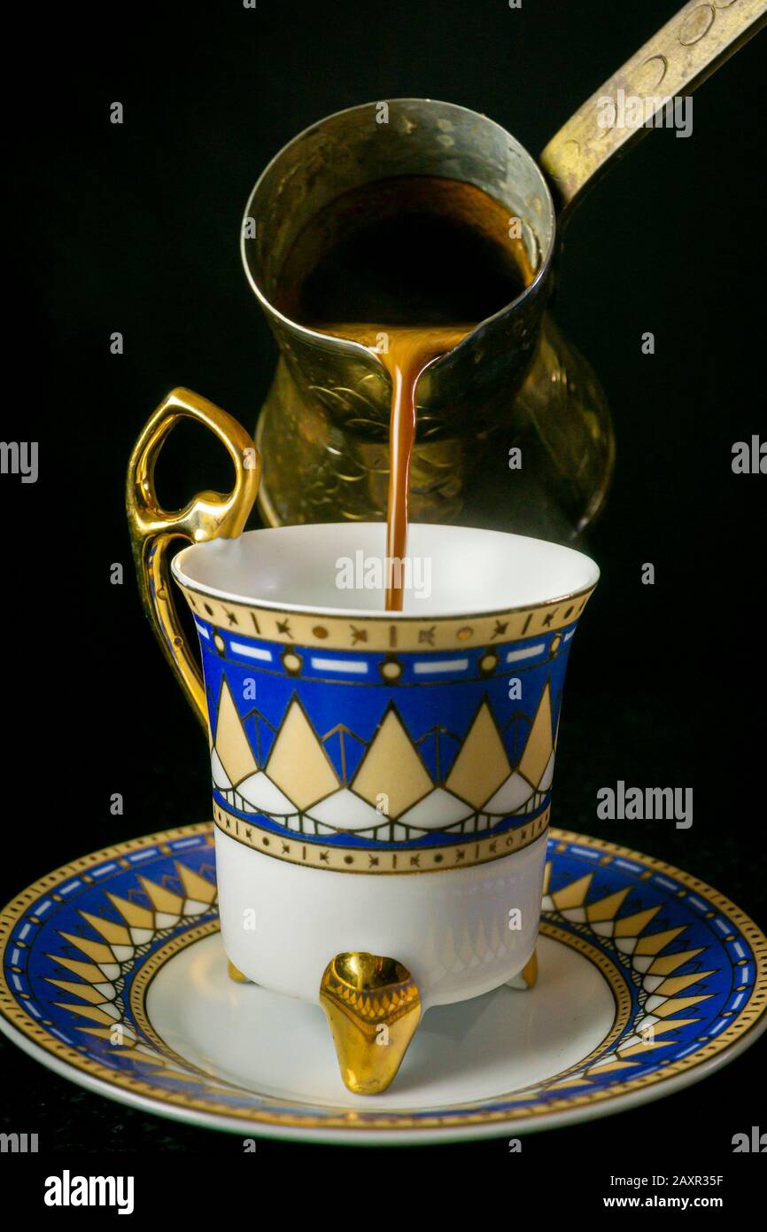 Pouring a cup of traditional Greek cup of coffee. Stock Photo