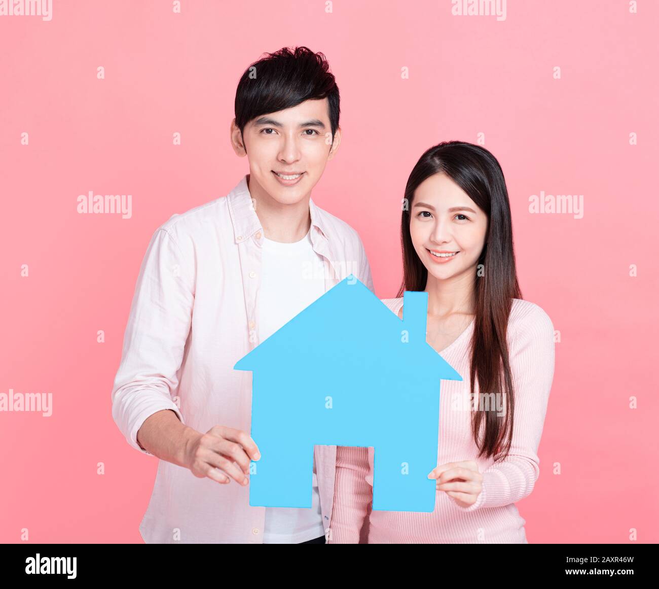 young couple hands holding paper house Stock Photo