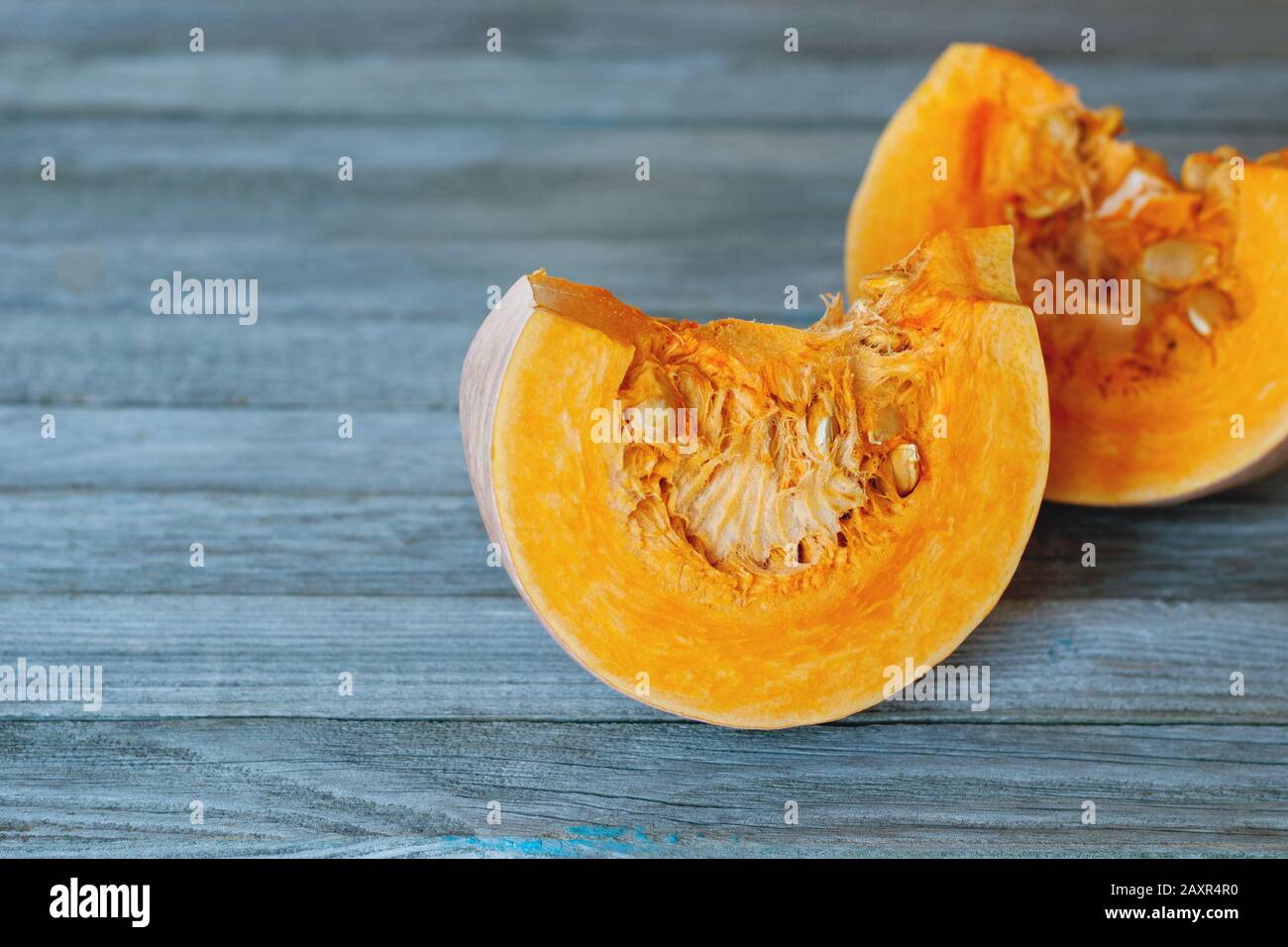 Two bright orange pumpkin slices on gray background Stock Photo