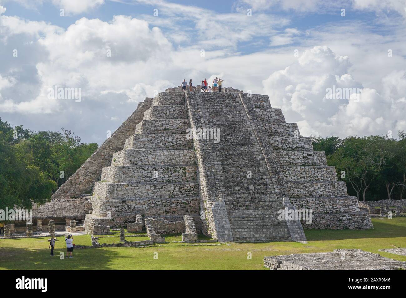 Mayapan, Mexico: Tourists visit the Mayan Temple of Kukulcan in Mayapan, the capital of the Maya in the Yucatán from the 1220s until the 1440s. Stock Photo
