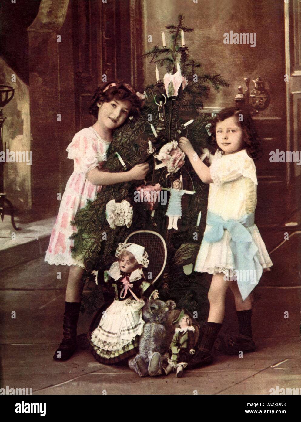 1900 ca , FRANCE :  Two little boy and girl in  CHRISTMAS  TIME , near a Xmas tress with with decorations and gifts from Santa Claus . Photo by undentifiend french photographer used for postcards in Italy  . - FOTO STORICHE - BABBO NATALE - pino - abete - pine - fir - HISTORY PHOTOS - FRANCIA - BUON NATALE - ALBERO di NATALE - Festività natalizie - BAMBINO - BAMBINI - BAMBINA - BAMBINE - CHILDREN - CHILD - CHILDHOOD - INFANZIA - NOVECENTO - '900 - 900's - XX CENTURY  - RELIGIONE CATTOLICA CRISTIANA - CATHOLIC RELIGION - fratello e sorella - brother and sister - fratelli - orsachiotto di peluch Stock Photo