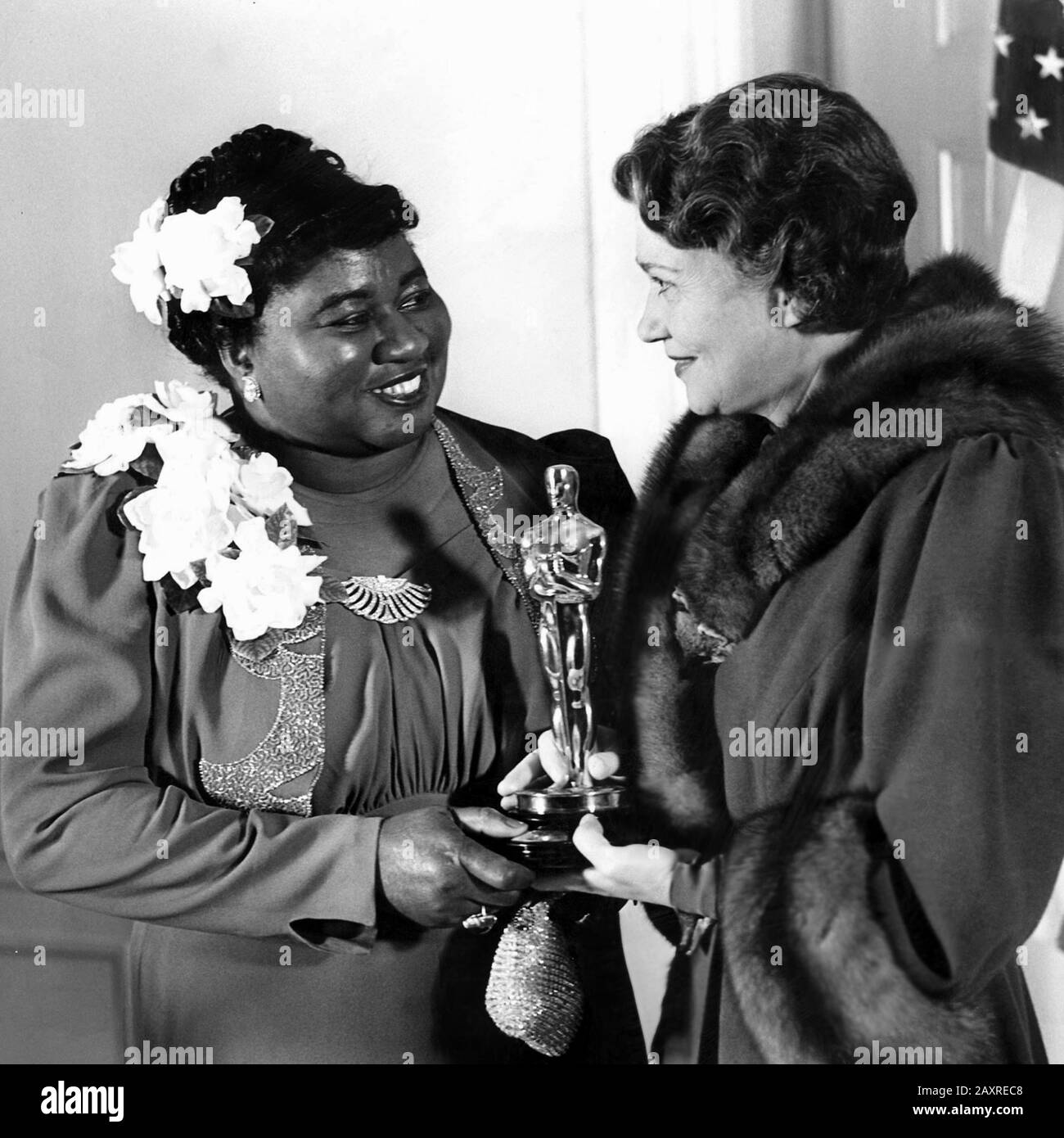 1940 , USA : HATTIE McDANIEL ( 1892 - 1952 ) receive from actress FAY BAINTER ( 1893 - 1968 ) the Oscar Award, at 1939 12th Academy Awards , for her role of MAMMIE  in movie GONE WITH THE WIND ( Via col Vento , 1939 ) by Victor Fleming , from the novel by Margaret Mitchell . Pubblicity Stills . - FILM - CINEMA - portrait - ritratto - FILM - premio - premiazione - statuetta - statuette - smile - sorriso ---  Archivio GBB Stock Photo