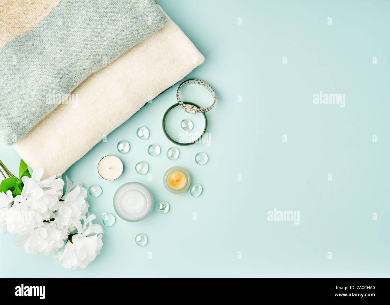Flat lay woman accessories with cosmetic, facial cream on pastel blue table, copy space. Stock Photo