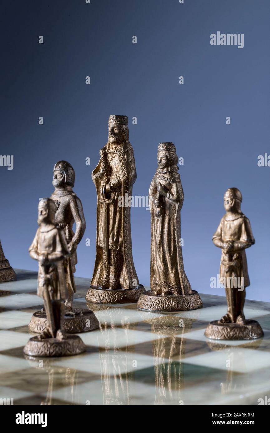 Сhess as an abstract concept. Beautiful antique chess set on marble chess board. Stock Photo