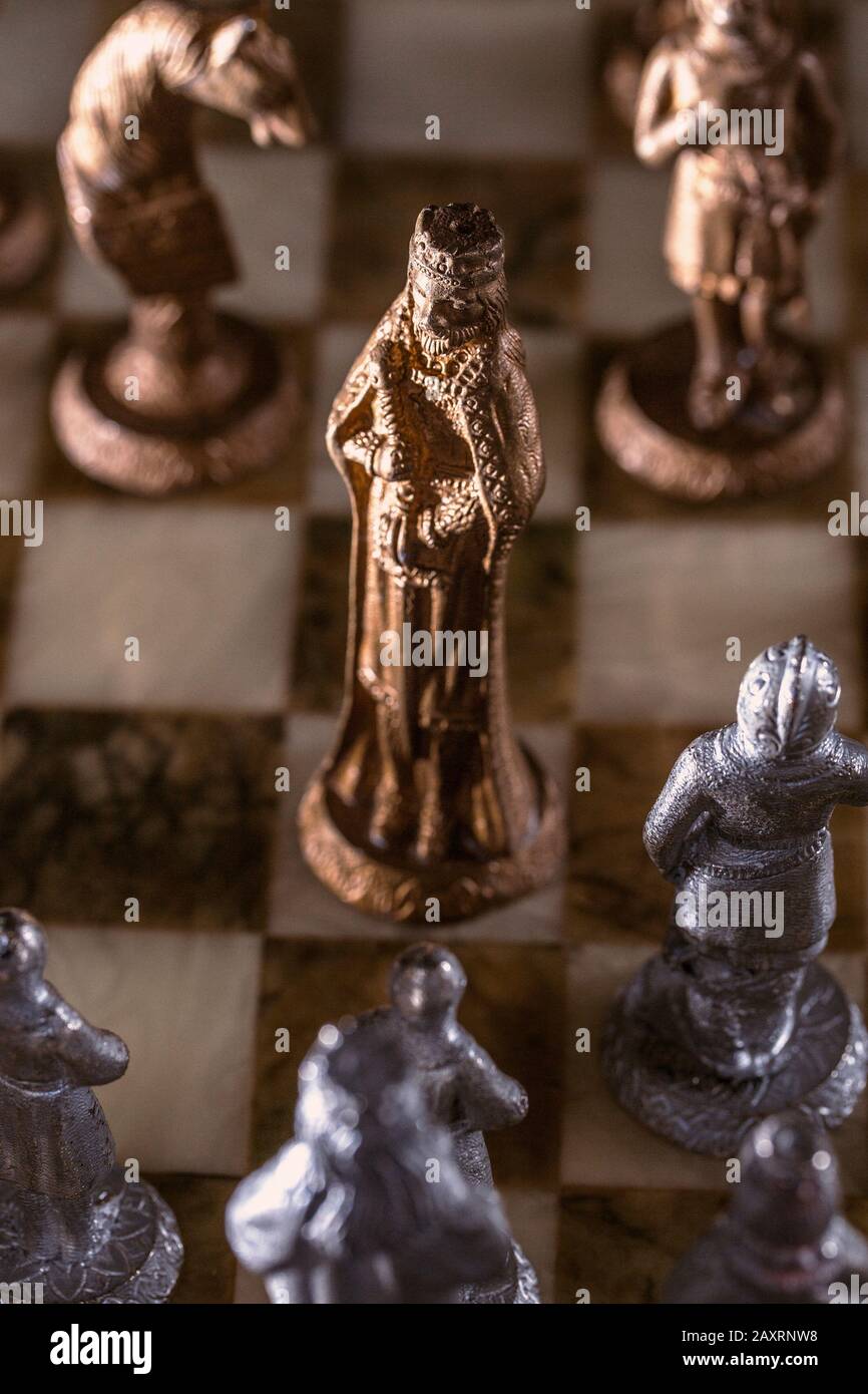 Сhess as an abstract concept. Beautiful antique chess set on marble chess board. Stock Photo