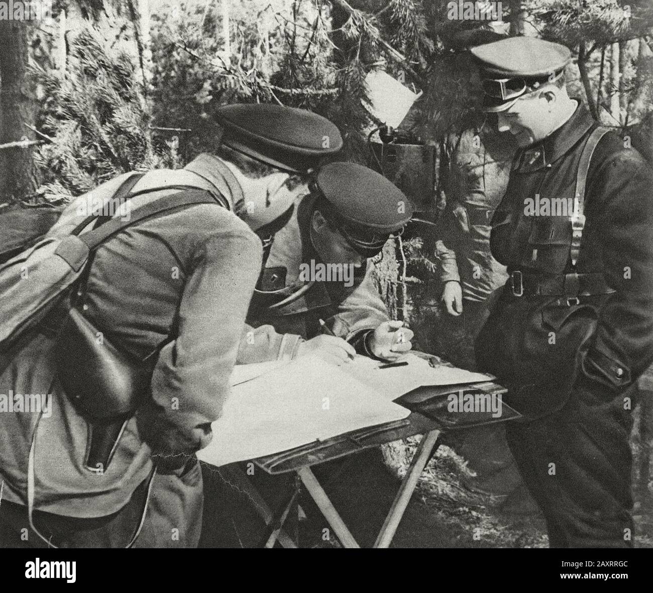 Red Army in 1930s. From soviet propaganda book of 1937. Soviet officers of studying the map and setting the task Stock Photo