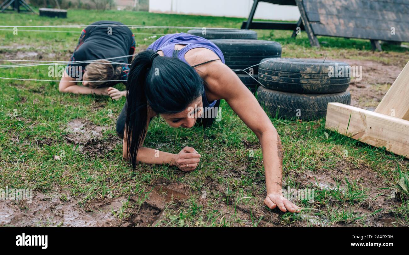 Participants in an obstacle course crawling Stock Photo