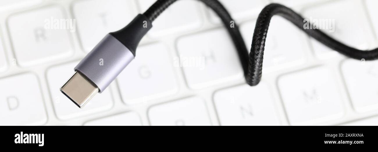 Usb type c cable against laptop keyboard background. Stock Photo