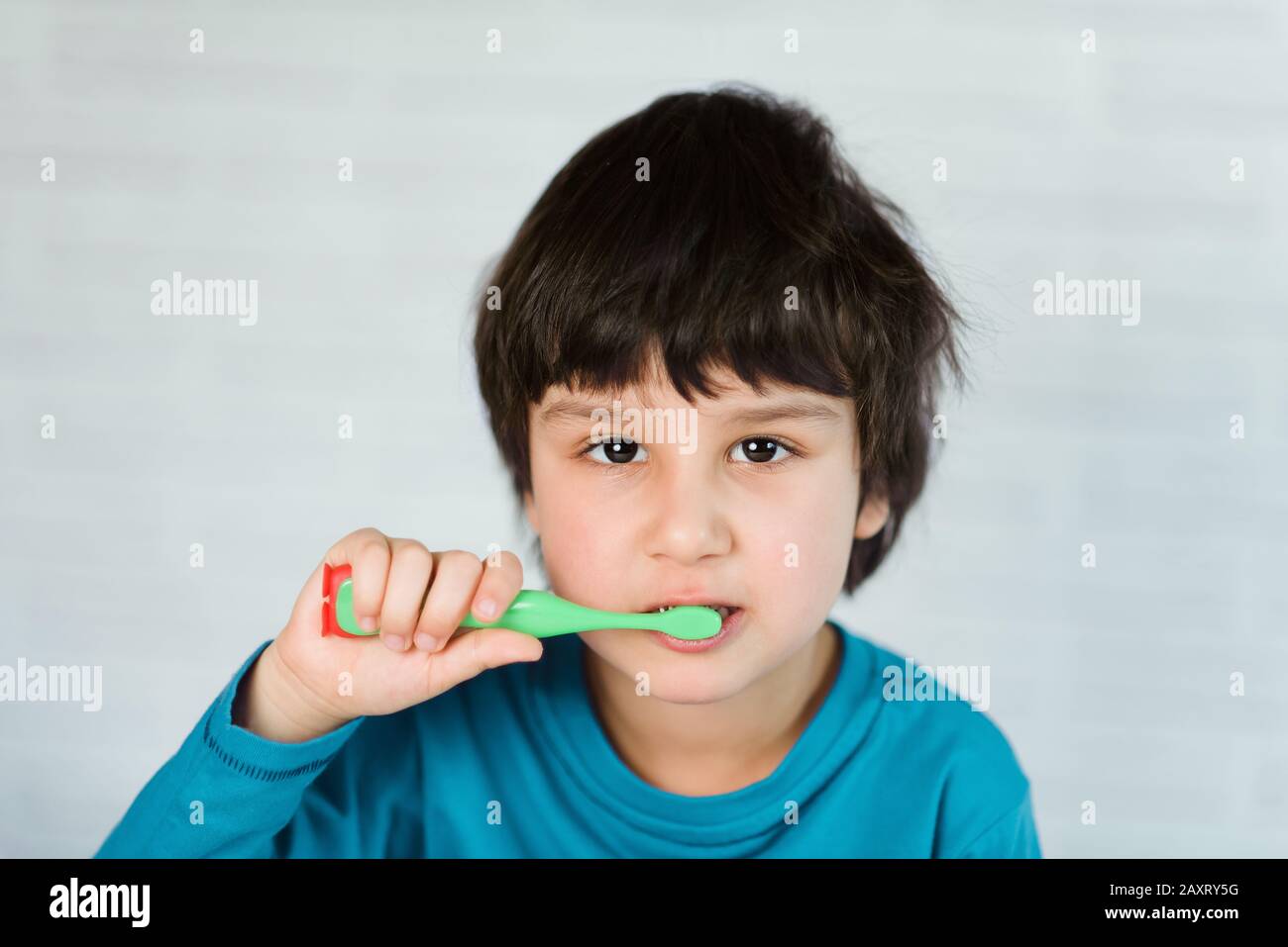Little boy brushing his teeth on white background. little child cleans