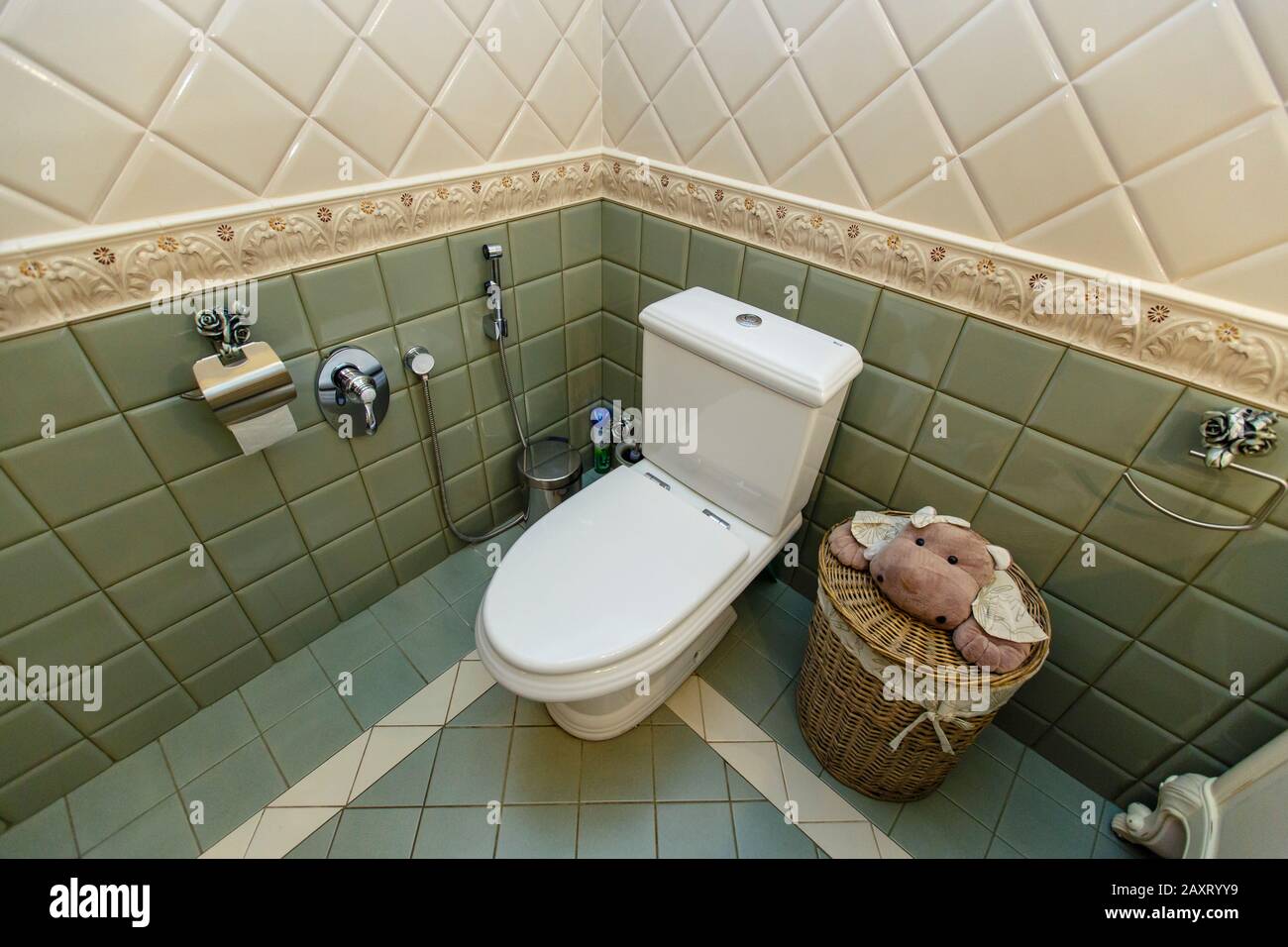 Beautiful and expensive bathroom. Toilet. White and green tiles. Paper