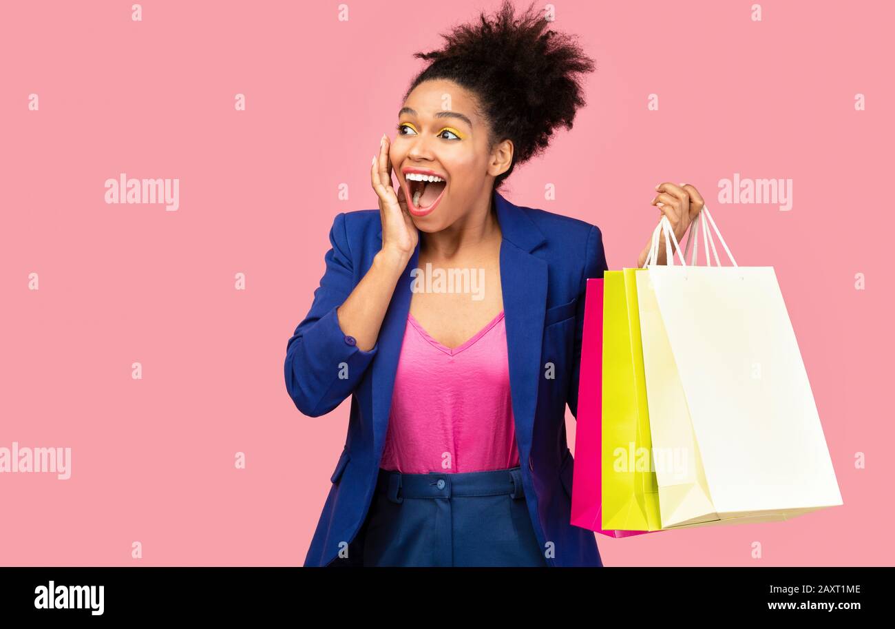 Portrait of black woman holding shopping bags Stock Photo