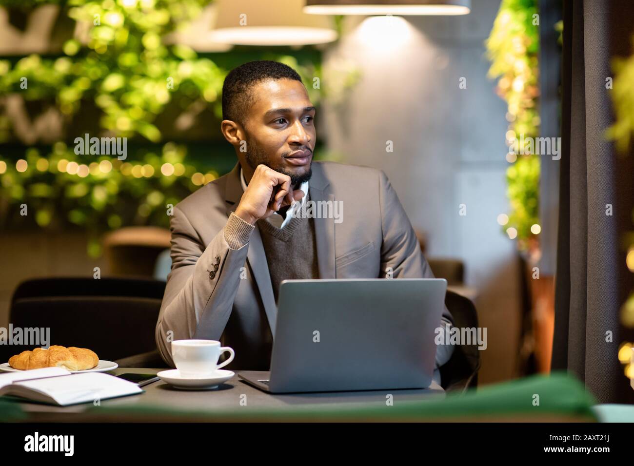 Afro manager drinking tea and using personal computer at cafe Stock Photo