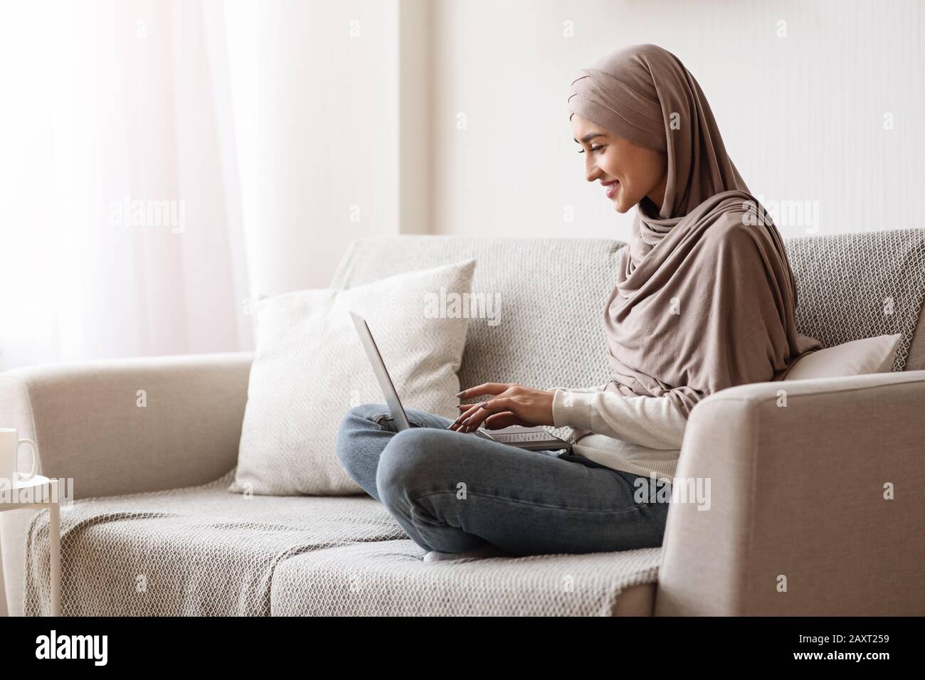 Young Arabic Woman Freelancer In Hijab Using Laptop At Home Stock Photo ...