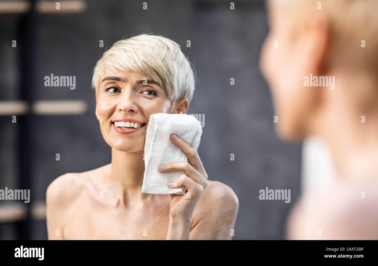 Lady Drying Face With Towel Doing Skincare Routine In Bathroom Stock