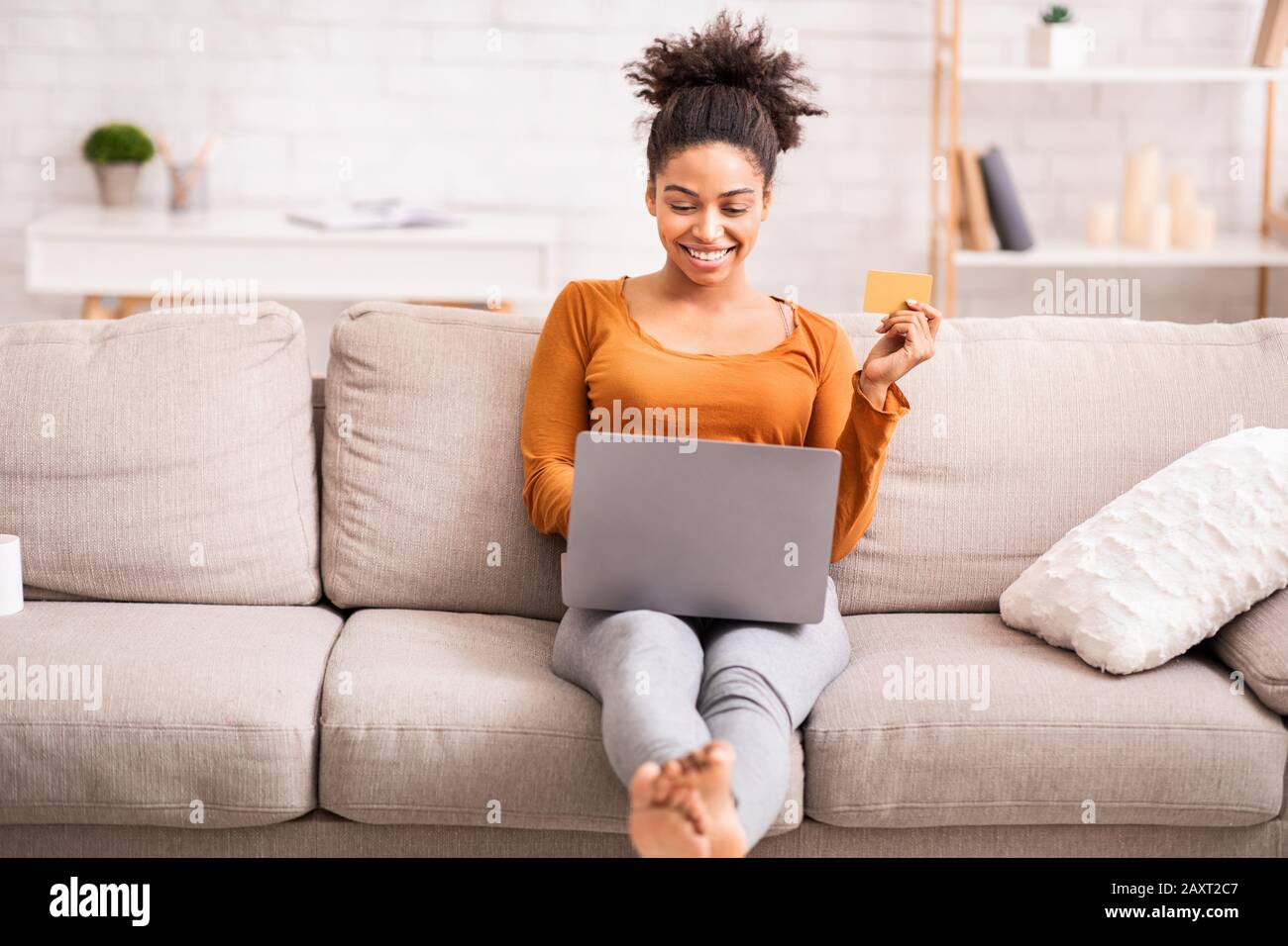 Afro Woman With Laptop And Credit Card Sitting On Sofa Stock Photo - Alamy