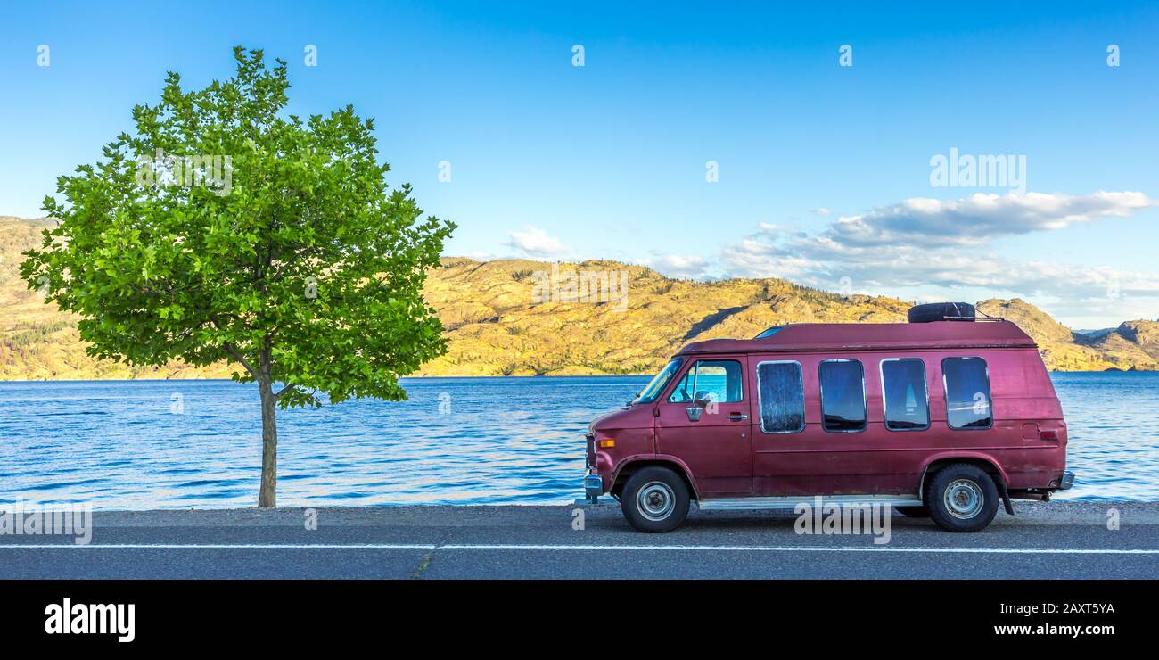 Old Campervan parking next to a tree at Okanagan Lake, British Columbia, Canada Stock Photo