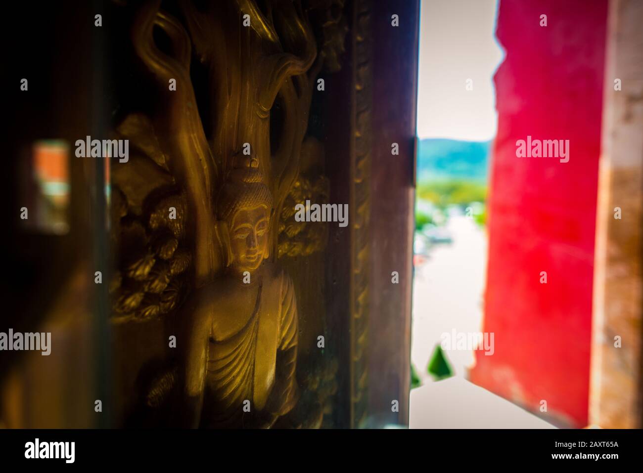 Wat Chalong,Phuket/Thailand-15December2019: Detail shot of a wood carving and gold inlay of lord buddha in a window frame of the grand pagoda. Stock Photo