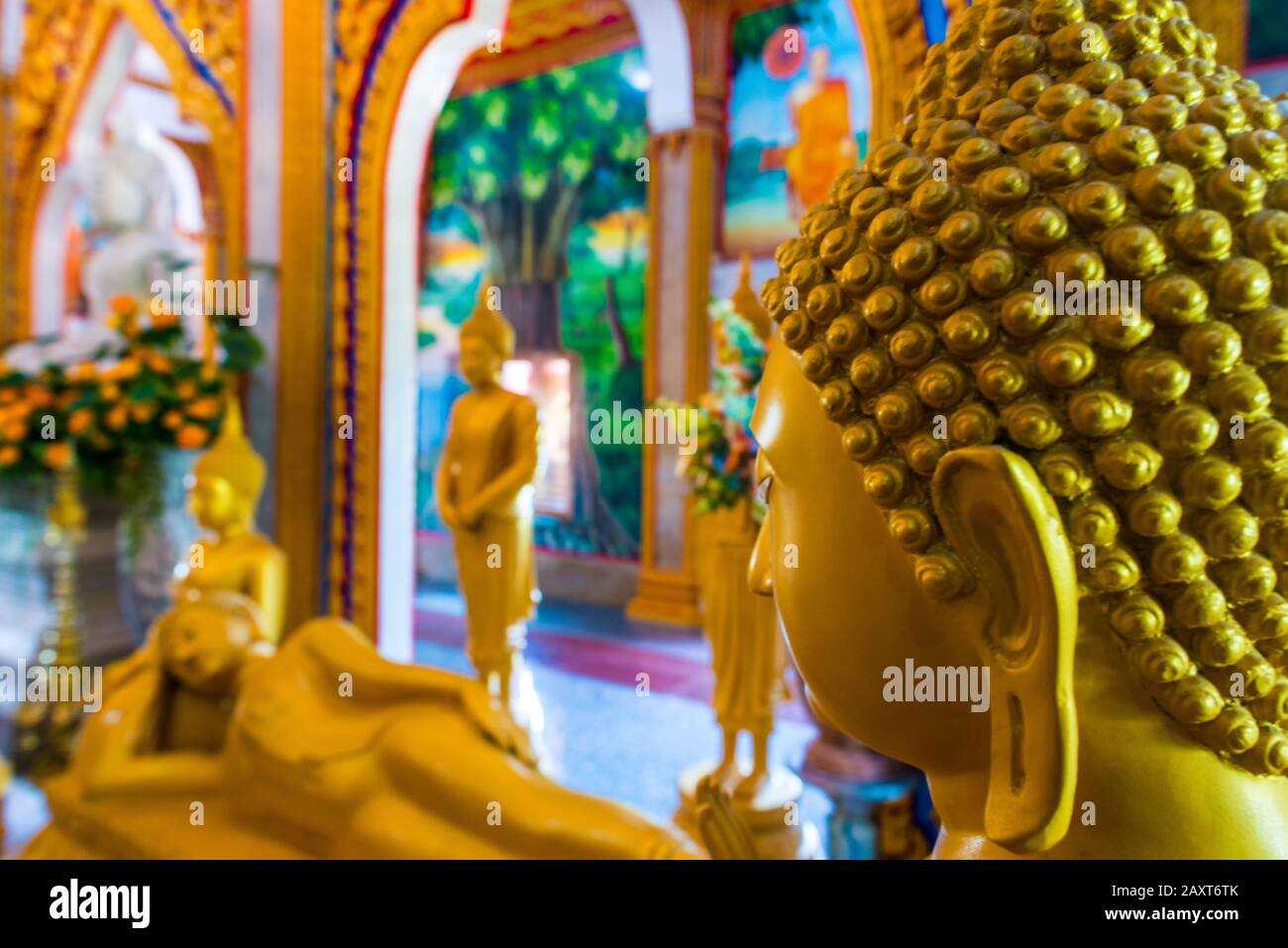 Wat Chalong,Phuket/Thailand-15December2019: Detail shot inside the first floor of the grand pagoda with statues in gold of lord buddha praying Stock Photo