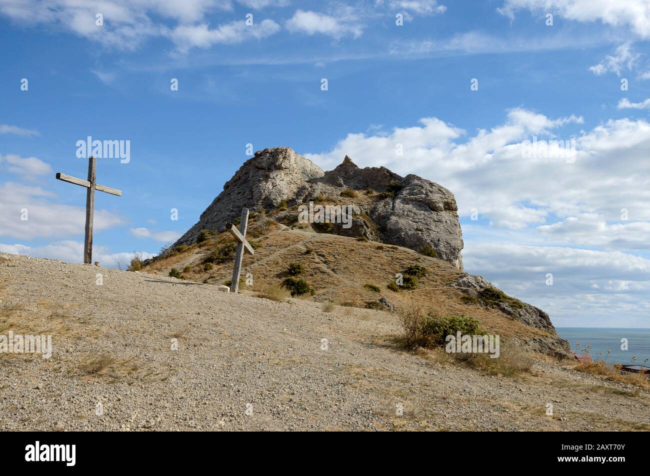 Scenic view towards top of Sugar Head rock from the north-western slope with two wooden crosses at movie shooting location in bright sunlight in Sudak Stock Photo