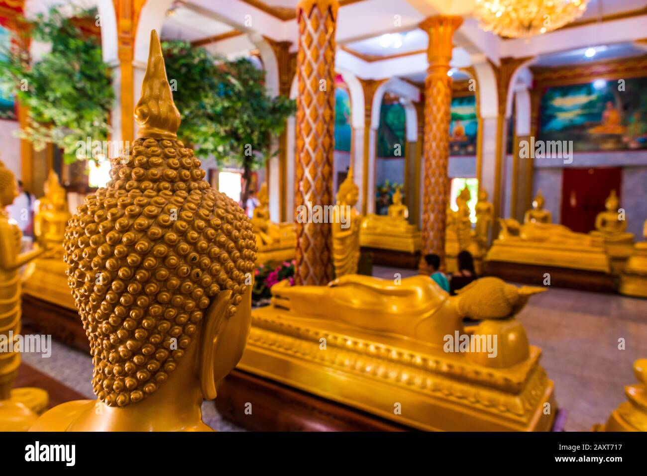 Wat Chalong,Phuket/Thailand-15December2019: Detail shot inside the first floor of the grand pagoda with statues in gold of lord buddha praying Stock Photo
