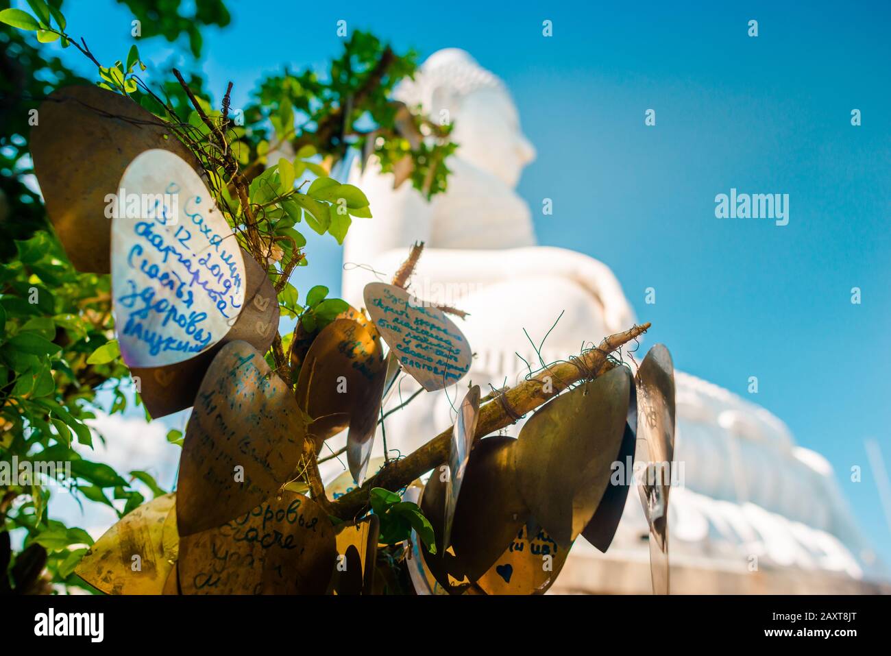Nakkerd Hill, Phuket/Thailand-15December2019: Golden heart shaped praying bells hanging together in a row with people spiritual notes written on them Stock Photo