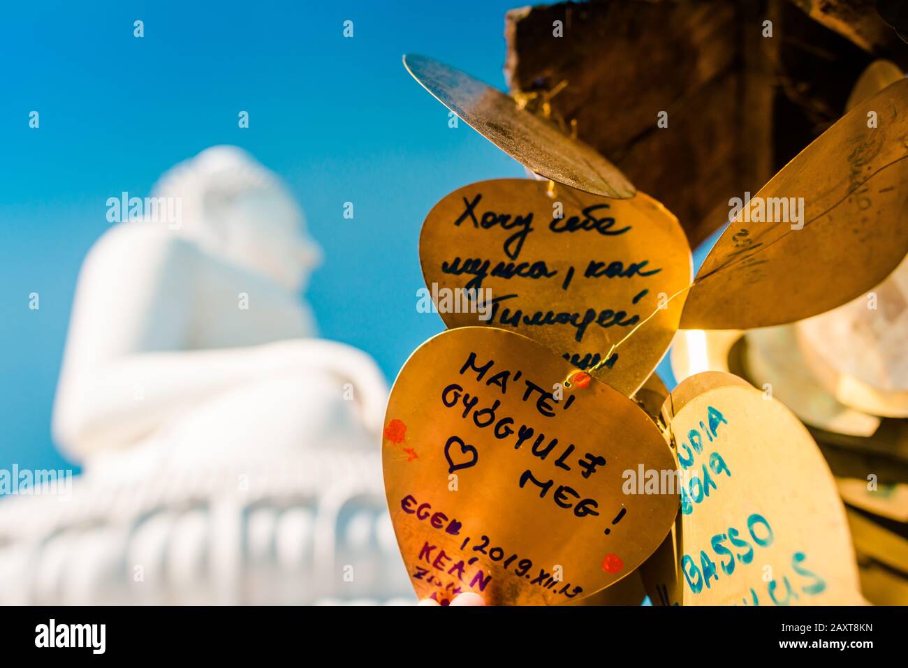 Nakkerd Hill, Phuket/Thailand-15December2019: Golden heart shaped praying bells hanging together in a row with people spiritual notes written on them Stock Photo