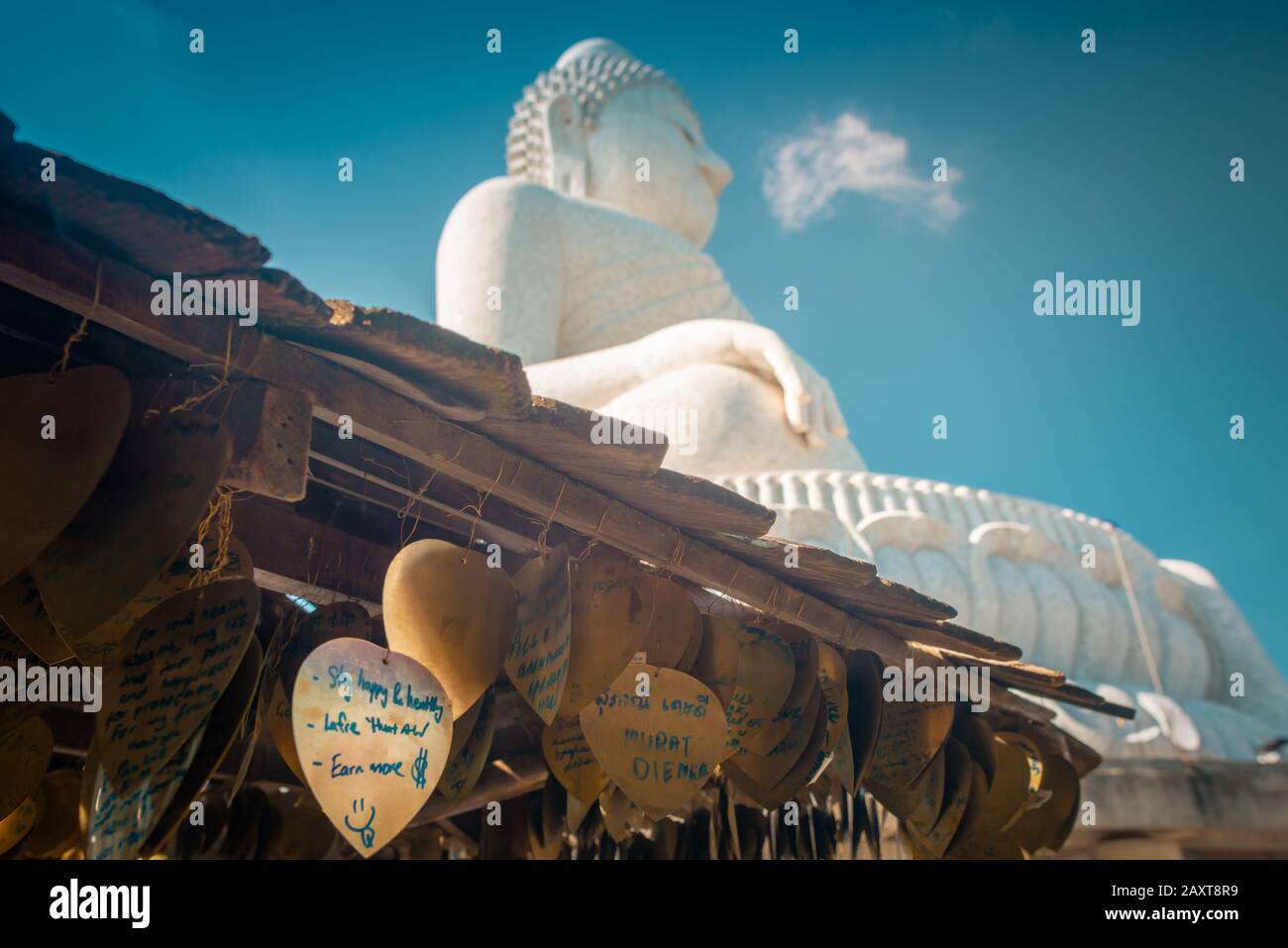 Nakkerd Hill, Phuket/Thailand-15December2019: Golden heart shaped praying bells hanging together in a row with people spiritual notes written on them Stock Photo