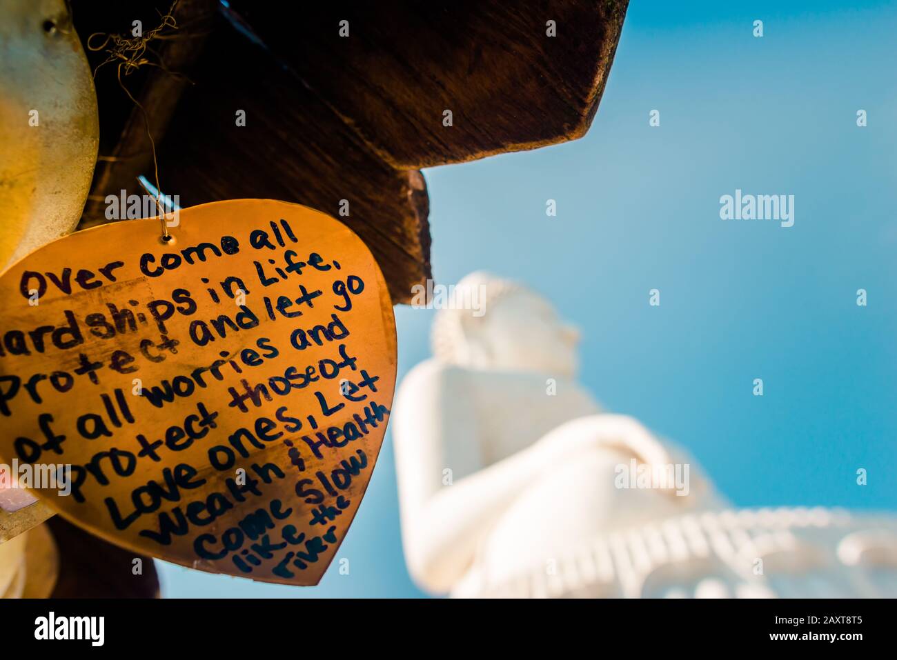 Nakkerd Hill, Phuket/Thailand-15December2019: Golden heart shaped praying bells hanging together in a row with people spiritual notes written on them Stock Photo