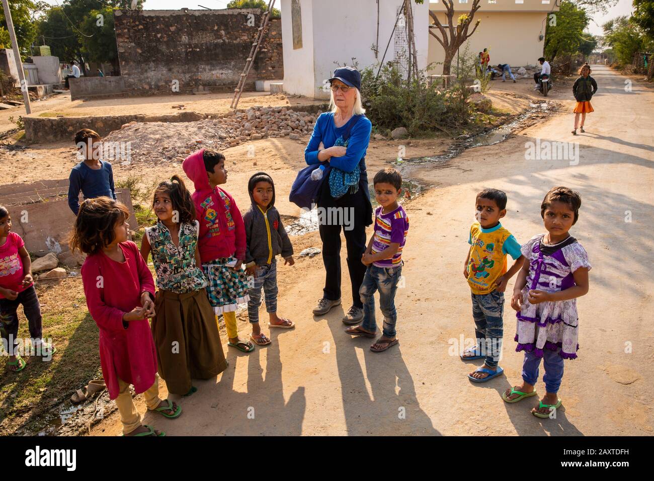 India, Rajasthan, Ranthambhore, Khilchipur, senior woman foreign  tourist surrounded by village children Stock Photo