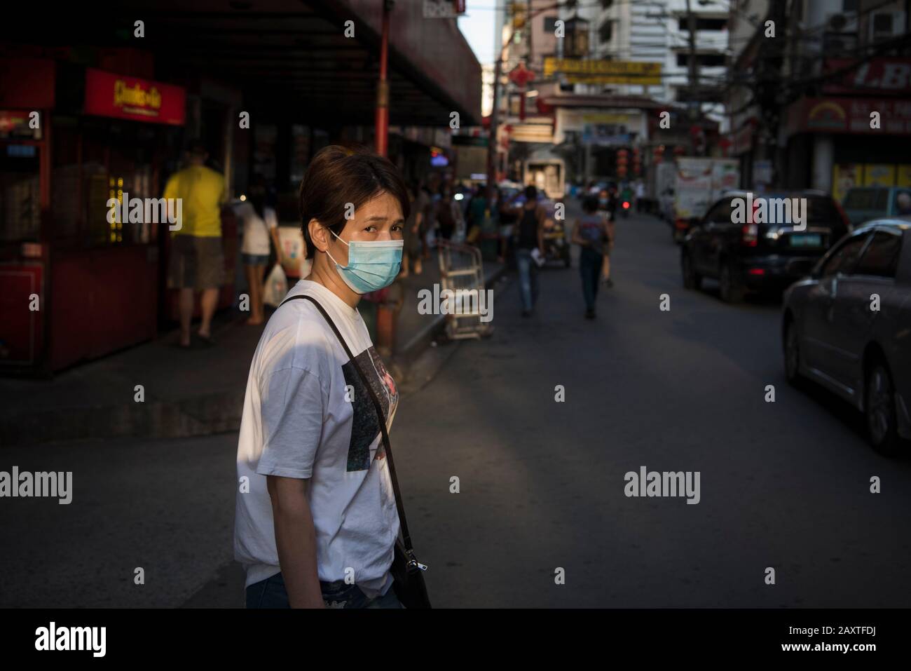 Manila, Philippines. 12th Feb, 2020. A woman wears a face mask in Manila's Chinatown district as a precaution to the outbreak of the coronavirus. Filipinos remain anxious over a new coronavirus known as Covid-19 which originated in Wuhan, China in December 2019. The Philippines' Department of Health announced the country's first death due to the virus on 2 February - the first reported death outside of China. The number of 2019-nCoV cases worldwide has already surpassed that of the 2003 Sars epidemic, with the death toll now over 1300. Credit: SOPA Images Limited/Alamy Live News Stock Photo