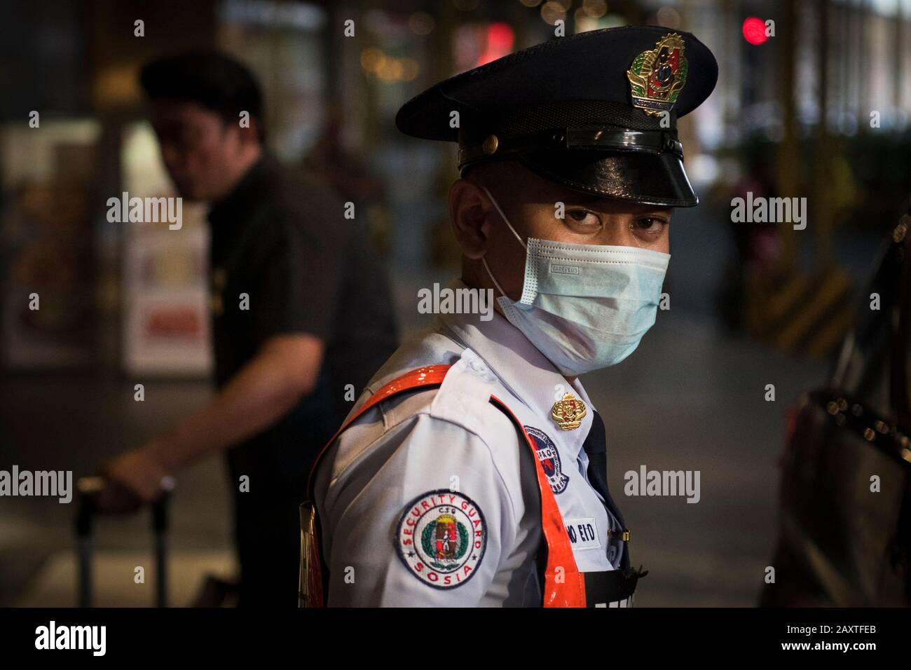 Manila, Philippines. 08th Feb, 2020. A security guard wears a face mask as a precaution to the outbreak of the coronavirus. Filipinos remain anxious over a new coronavirus known as Covid-19 which originated in Wuhan, China in December 2019. The Philippines' Department of Health announced the country's first death due to the virus on 2 February - the first reported death outside of China. The number of 2019-nCoV cases worldwide has already surpassed that of the 2003 Sars epidemic, with the death toll now over 1300. Credit: SOPA Images Limited/Alamy Live News Stock Photo