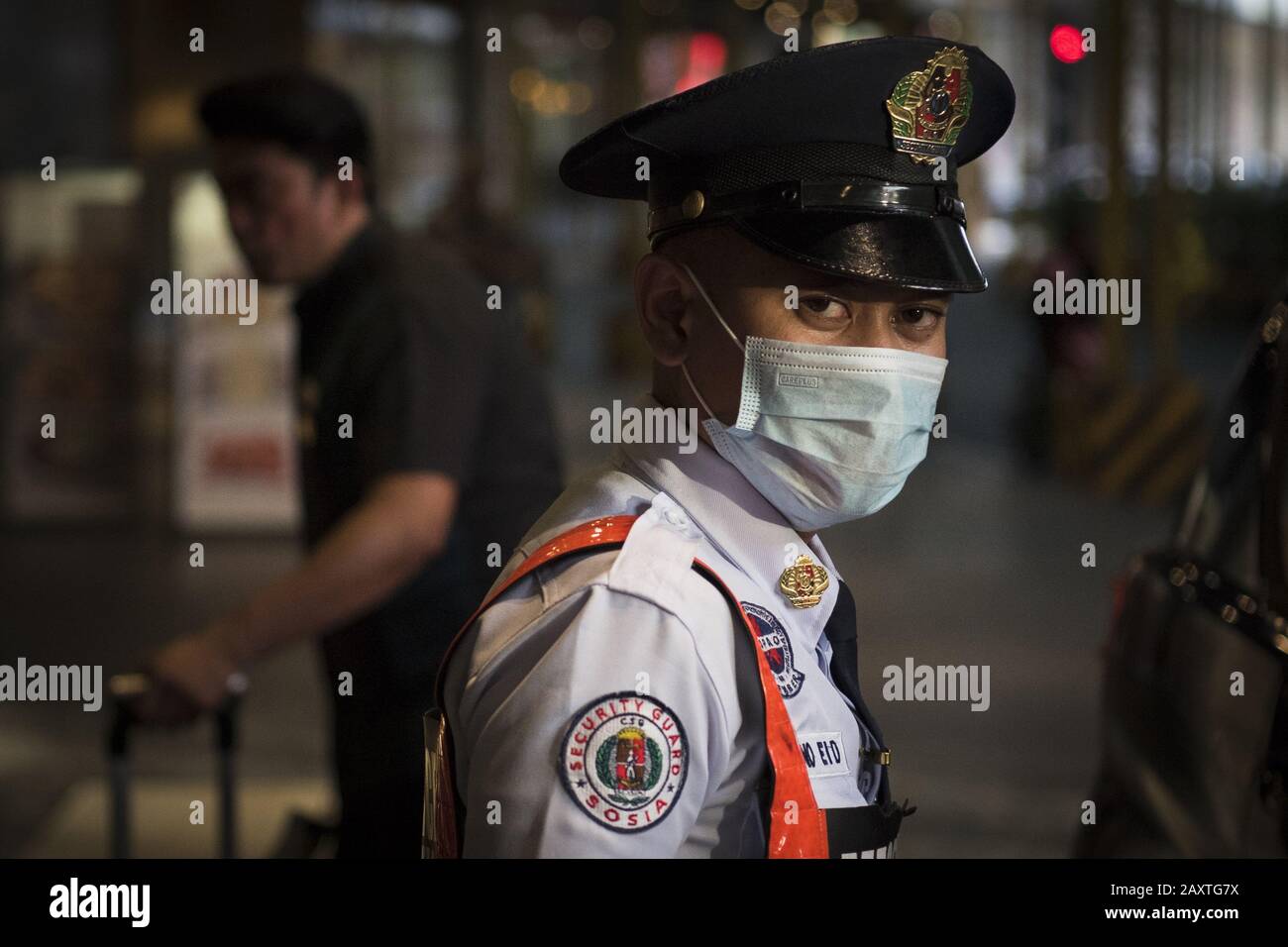 February 8, 2020, Manila, Luzon, Philippines: A security guard wears a face mask as a precaution to the outbreak of the coronavirus. Filipinos remain anxious over a new coronavirus known as Covid-19 which originated in Wuhan, China in December 2019.Â The Philippinesâ€™ Department of Health announced the countryâ€™s first death due to the virus on 2 February - the first reported death outside of China. The number of 2019-nCoV cases worldwide has already surpassed that of the 2003 Sars epidemic, with the death toll now over 1300. (Credit Image: © Oliver Haynes/SOPA Images via ZUMA Wire) Stock Photo