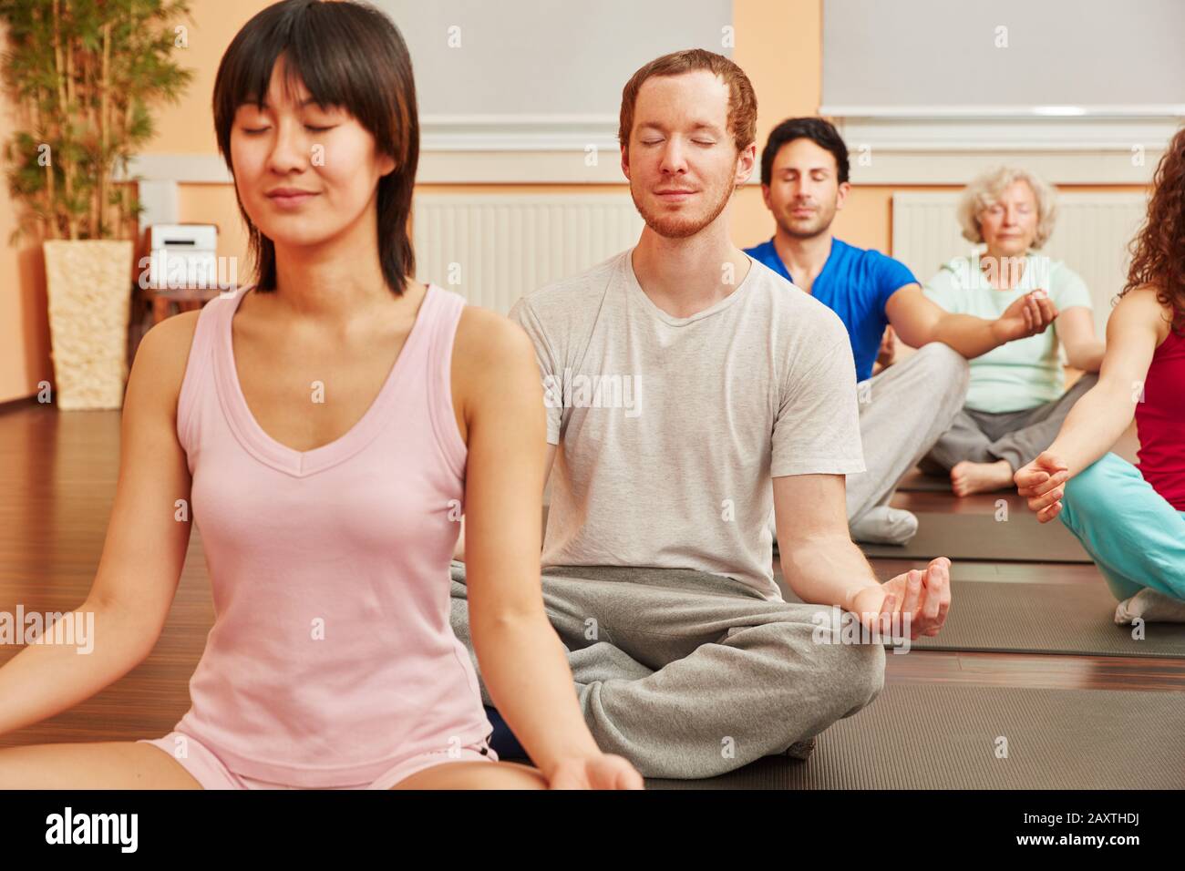 Group doing meditation for relaxation in yoga class Stock Photo