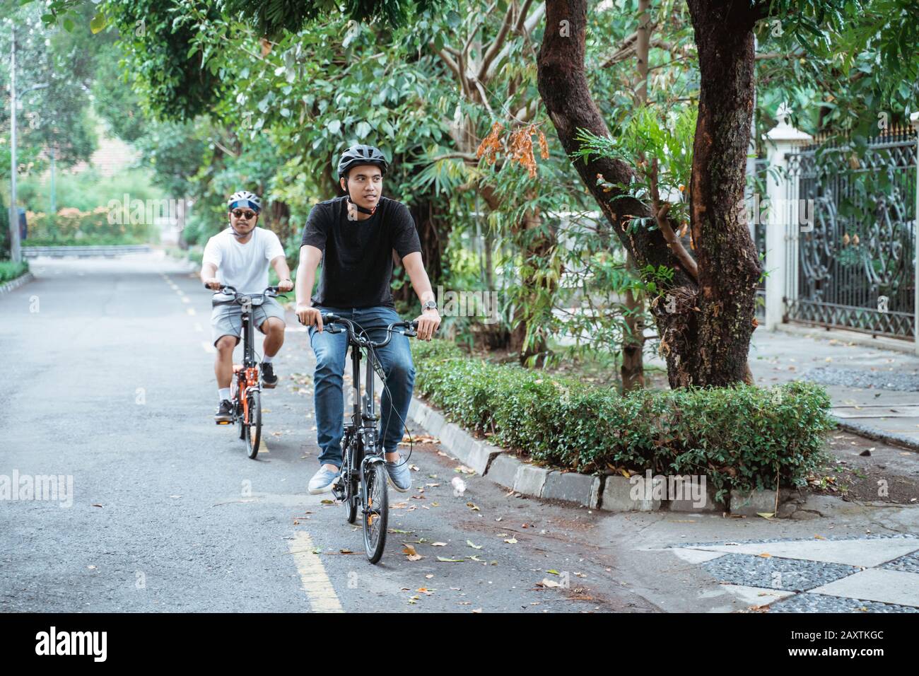Two young man wearing helmets enjoy riding bikes together on trips in ...