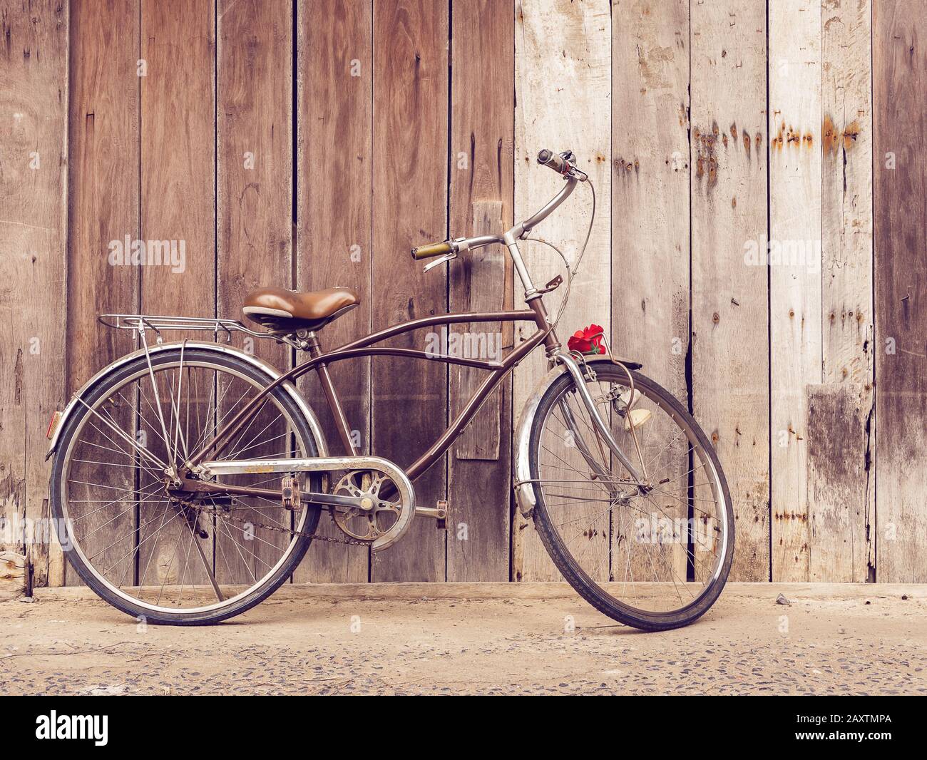 cyclists outdoor lifestyle. Classic vintage retro bicycle against the wooden old crack wall at home in Asia countryside. Old bike vintage style backgr Stock Photo
