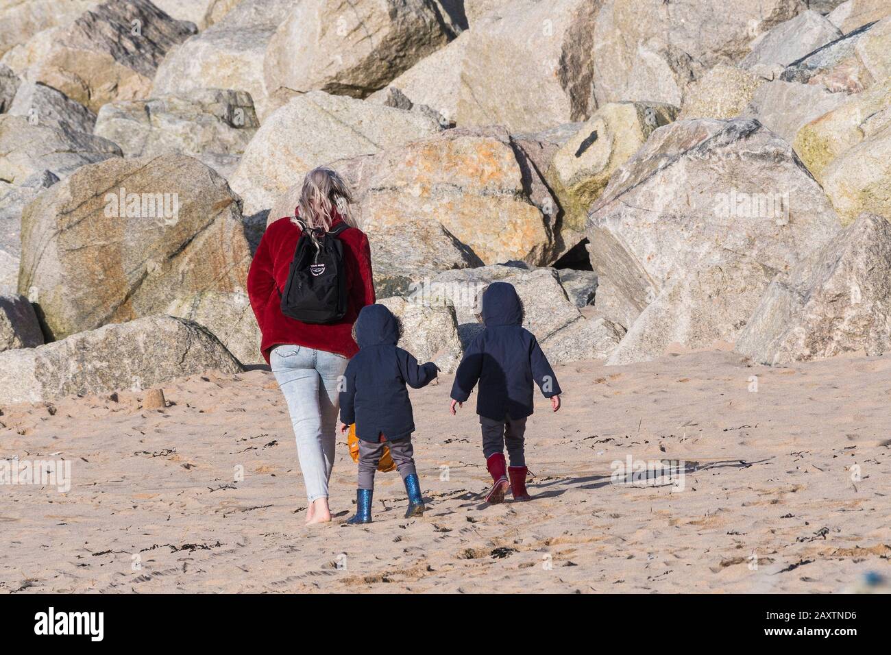 A mother enjoying walking with her toddlers on the beach at Fistral in Newquay in Cornwall. Stock Photo