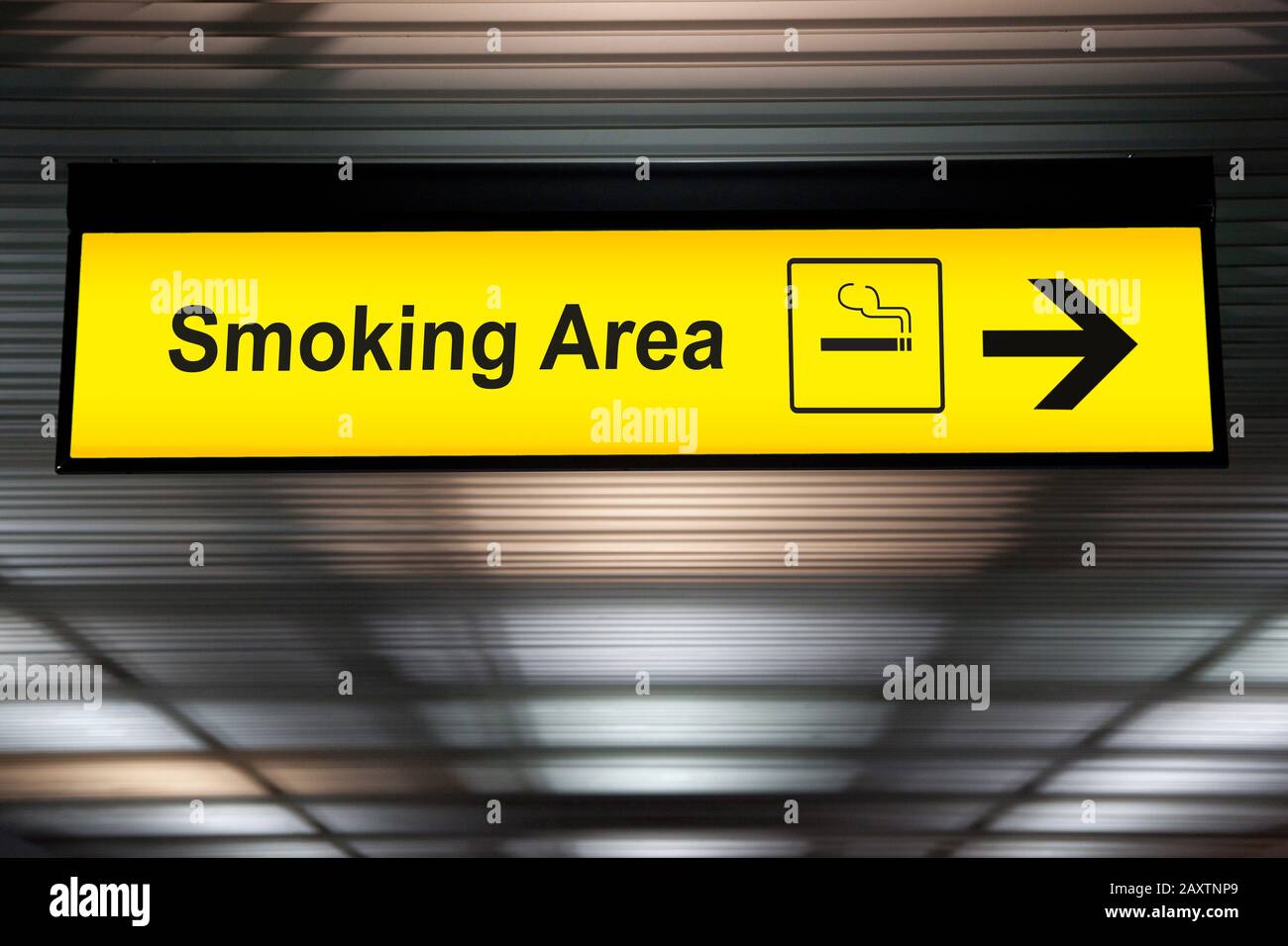 smoking area sign with icon and arrow pointing to smoking area zone hanging from airport ceiling