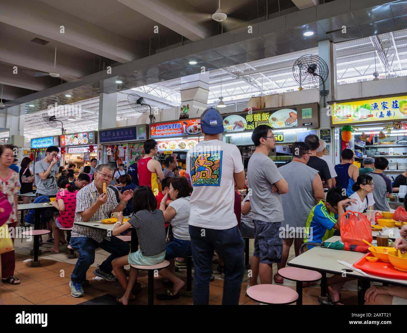 SINGAPORE – 4 JAN 2020 – Asian Chinese diners having a meal and socialising at a crowded self-service hawker centre in Ang Mo Kio, Singapore, Southeas Stock Photo