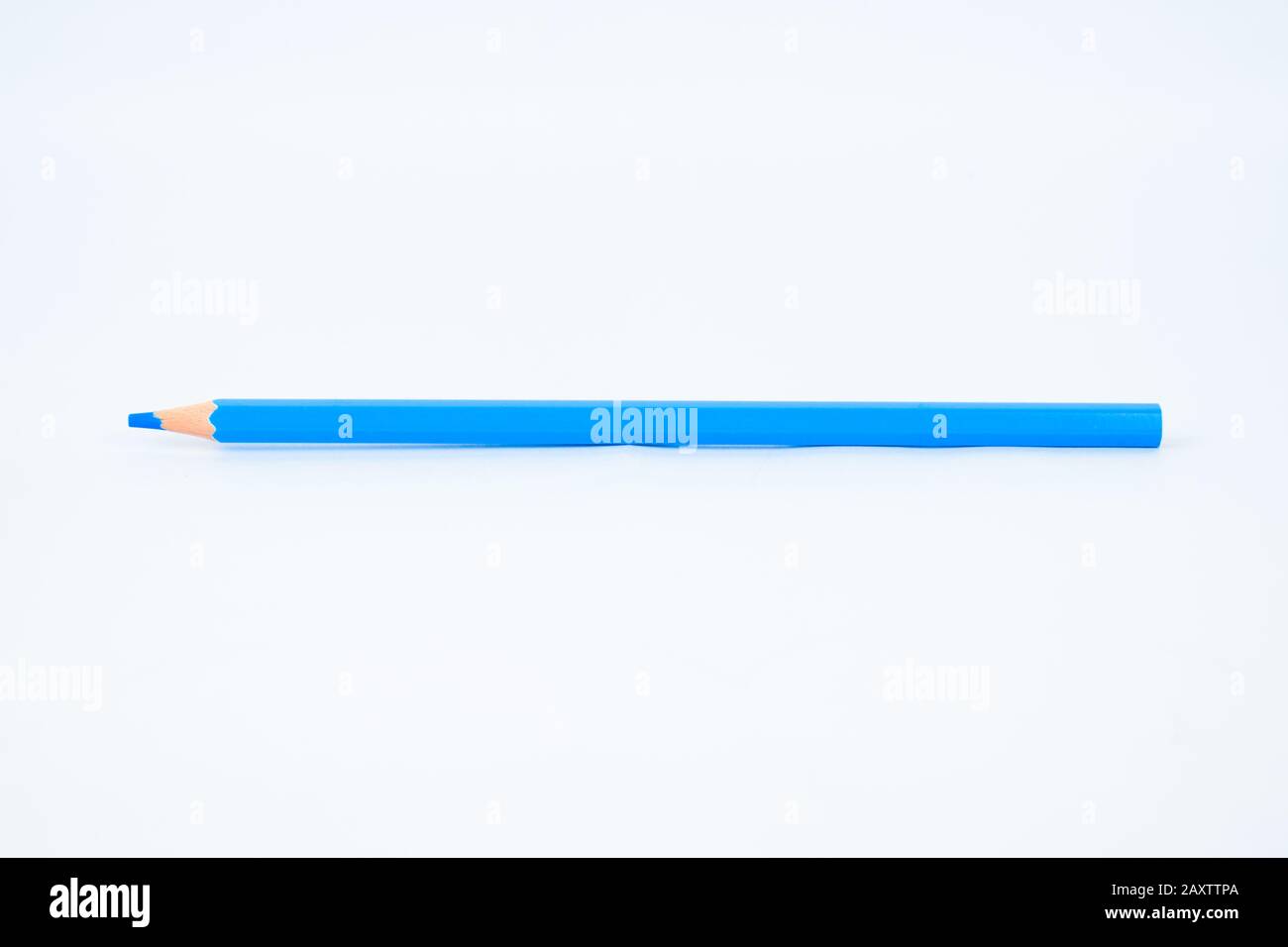 Light blue colored sharp wood pencil crayon is displayed on an isolated