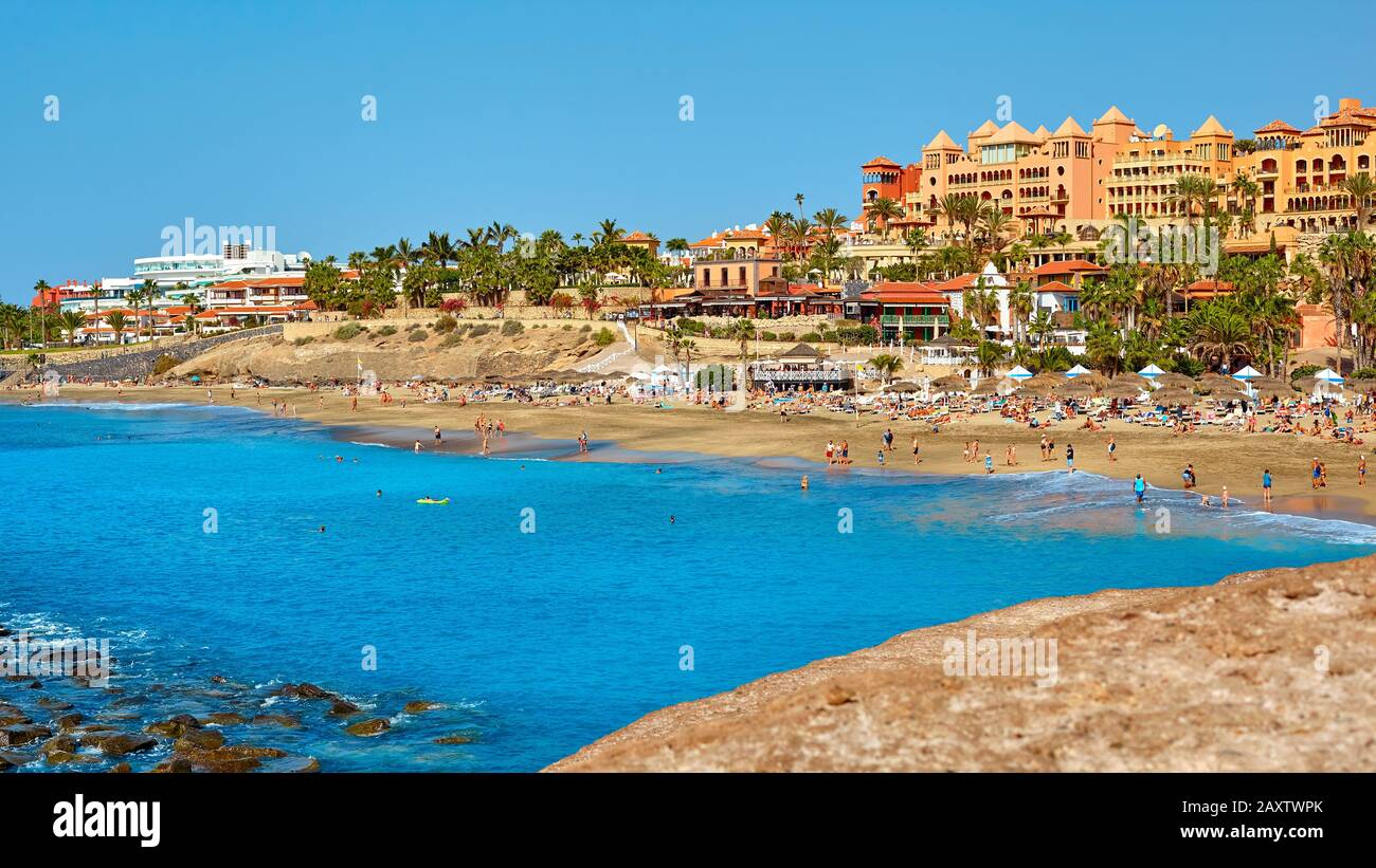 Tenerife island landscape. Blue ocean and beach with sunbathing peoples. Seaside resort at summer day. Stock Photo