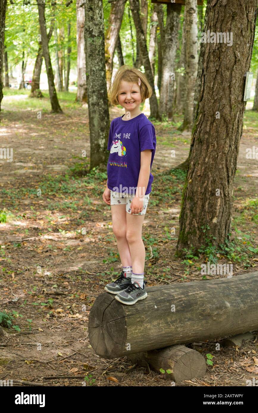 Young girl girls child kid on a children obstacle course activity Trail in woodland forest tree, at an adventure park in France during the summer. (112) Stock Photo