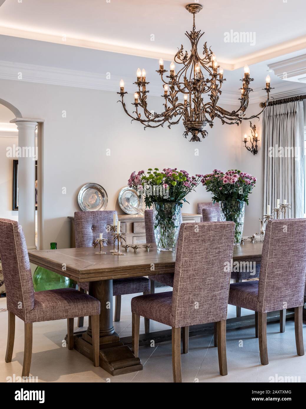 Dining room with purple chairs and chandelier Stock Photo - Alamy