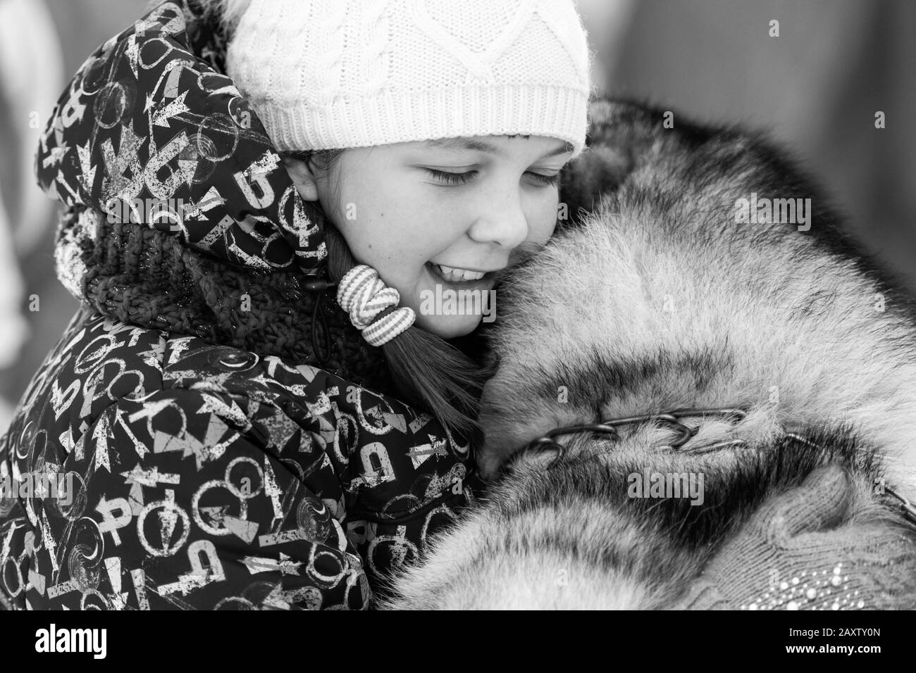 Husky dog hugs with beautiful girl. Winter outdoor walking. Black and white. - Reshetikha, Russia - 02.02.2019 Stock Photo