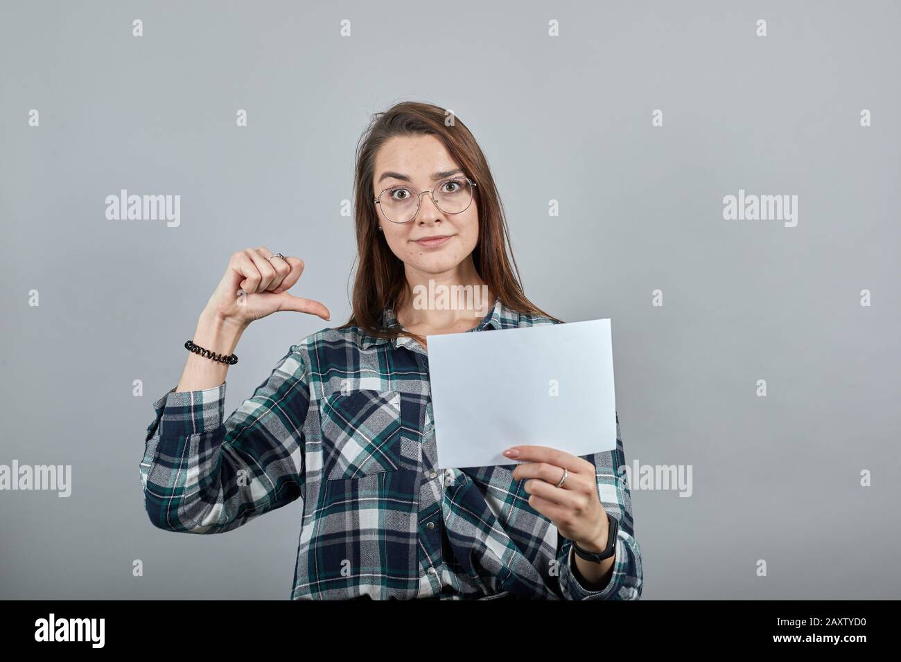 happy woman with glasses holds a white sheet of paper in her hand ...