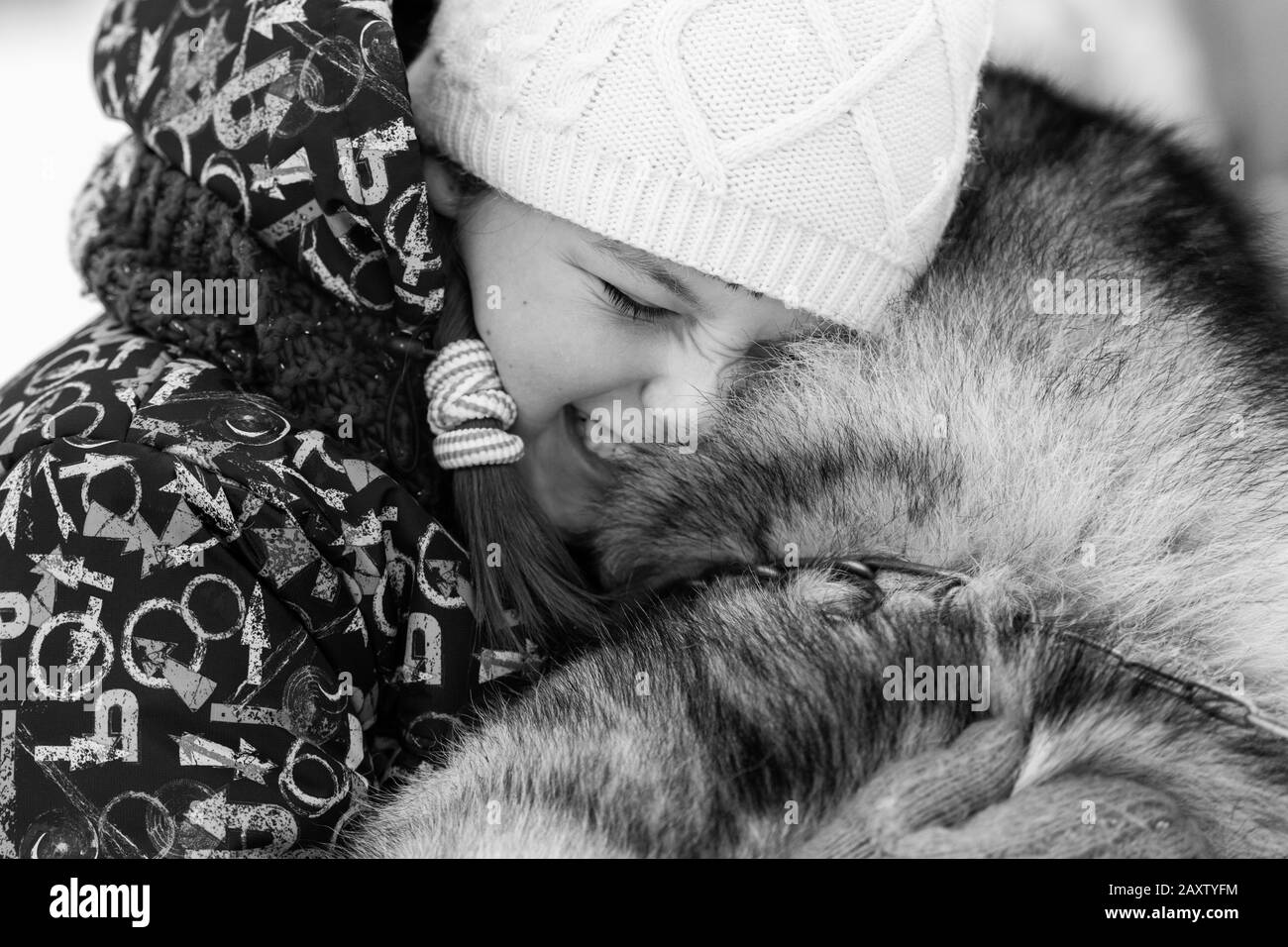 Husky dog hugs with beautiful girl. Winter outdoor walking. Black and white. - Reshetikha, Russia - 02.02.2019 Stock Photo